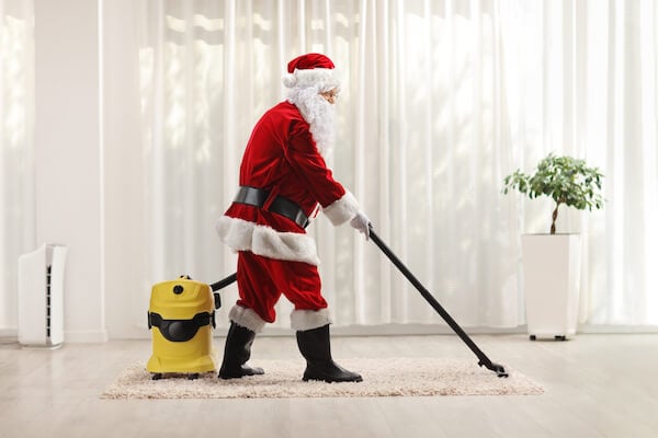Professional cleaner dressed as Santa cleaning the floor